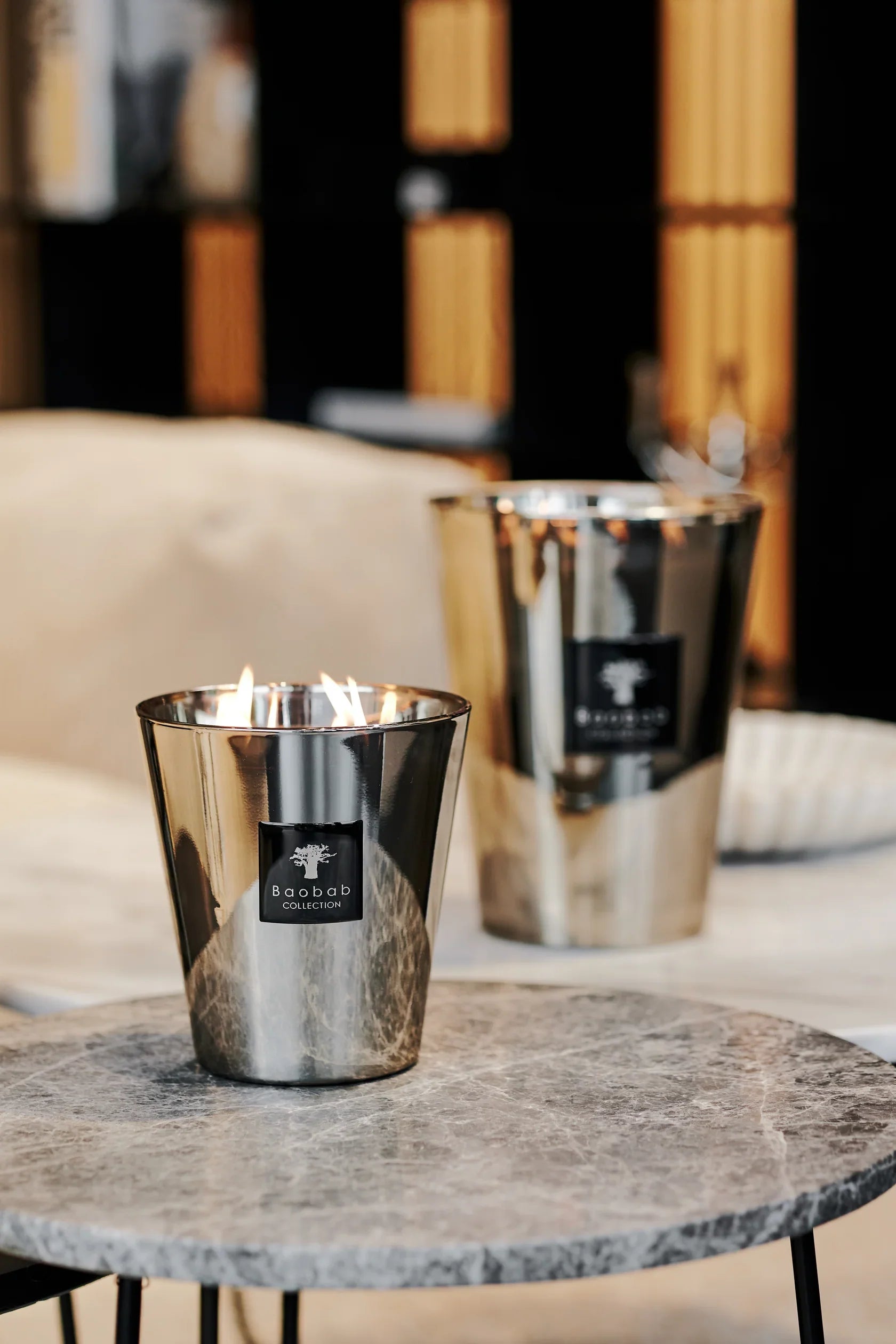 Elegant Baobab Collection Platinum candle glowing on a marble table, enhancing the room's luxurious atmosphere.