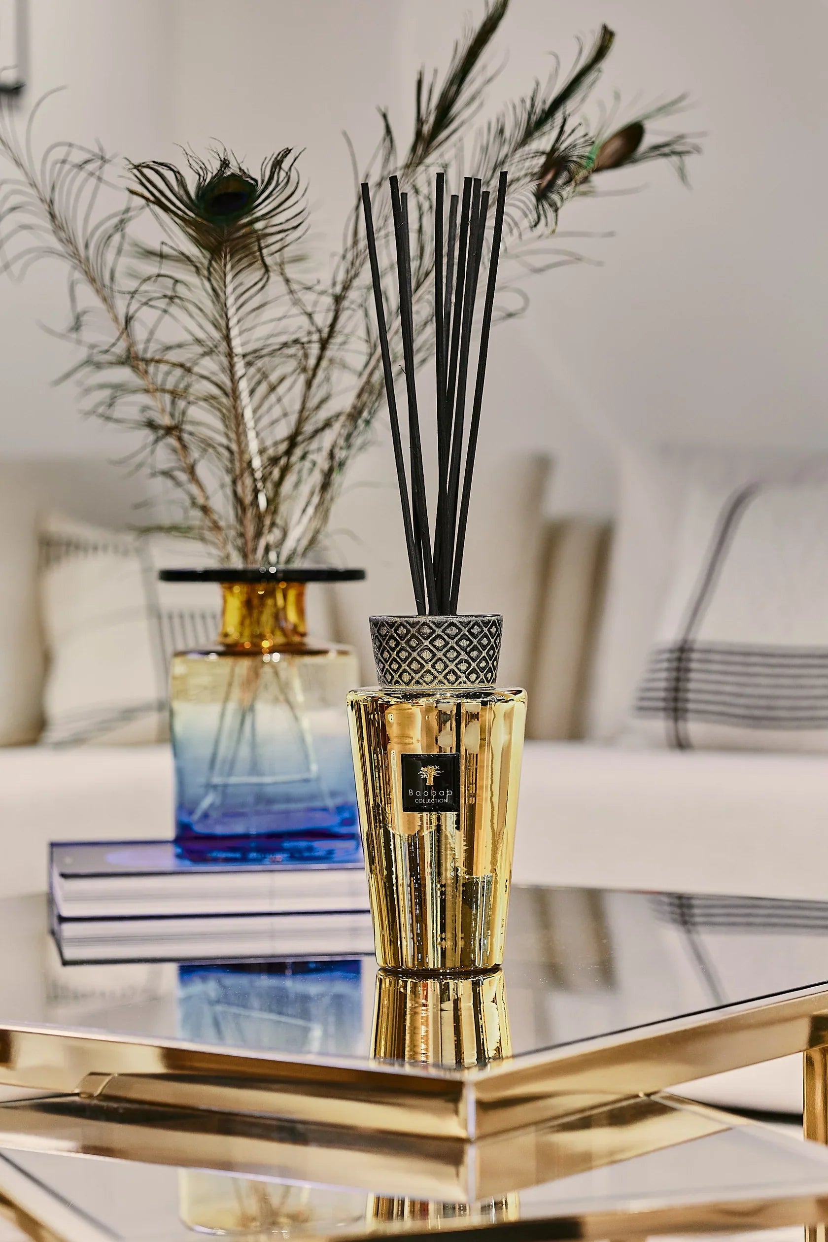 Baobab Collection TOTEM LES EXCLUSIVES AURUM diffuser with black sticks and gold finish on a stylish table.