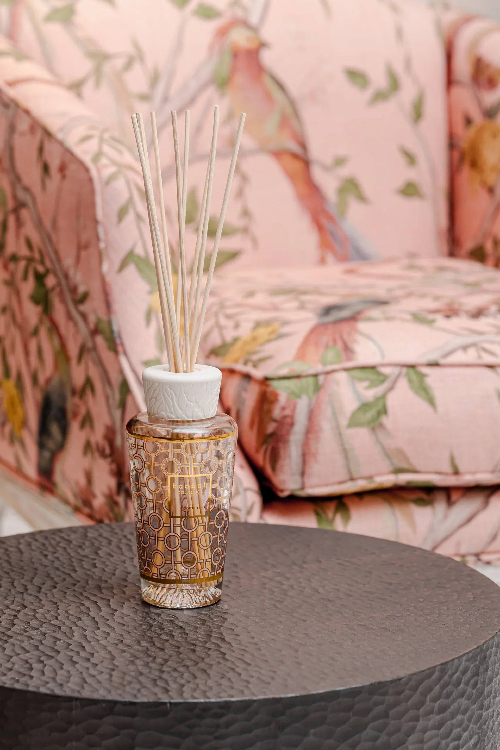 Baobab Collection My First Baobab diffuser with feminine aroma, gold and pink design on a decorative table.