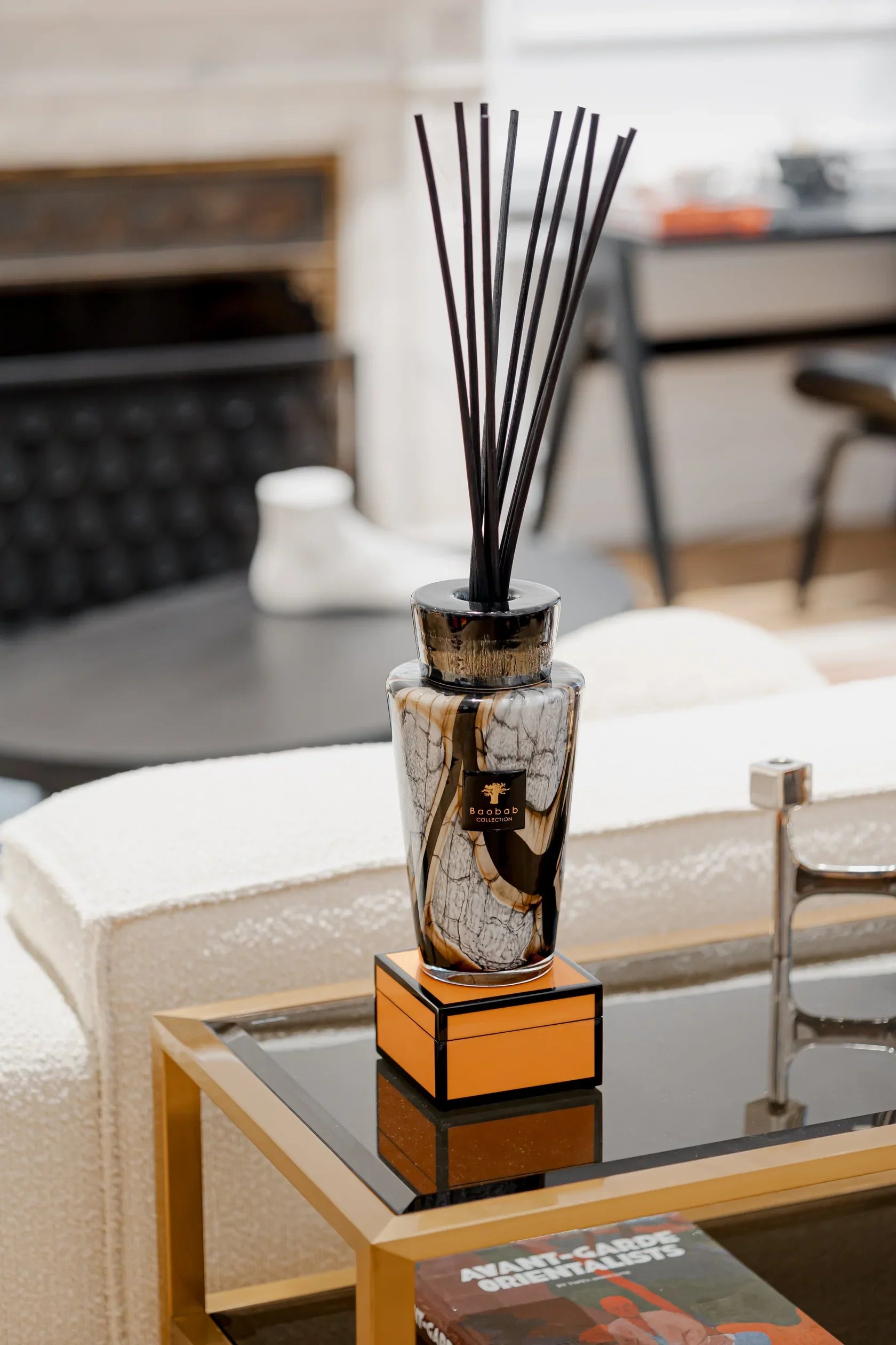 Baobab Collection Totem Stones Marble diffuser with black sticks, elegantly displayed on a modern coffee table.