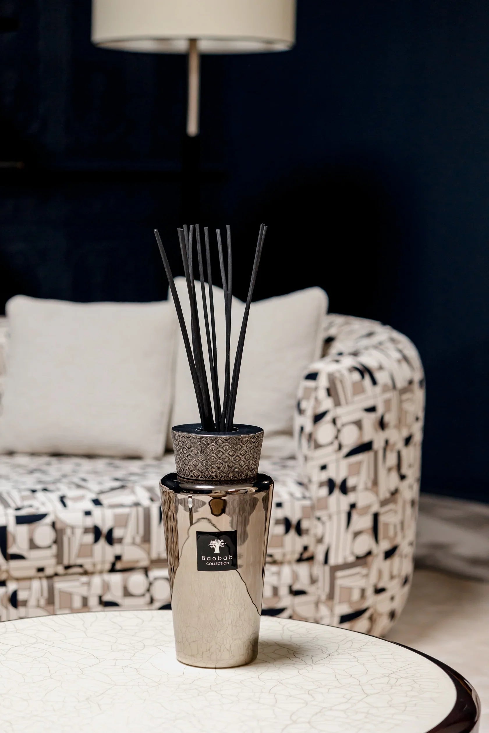 Baobab Collection TOTEM Platinum diffuser with sticks, stylishly displayed on a coffee table in a modern living room.