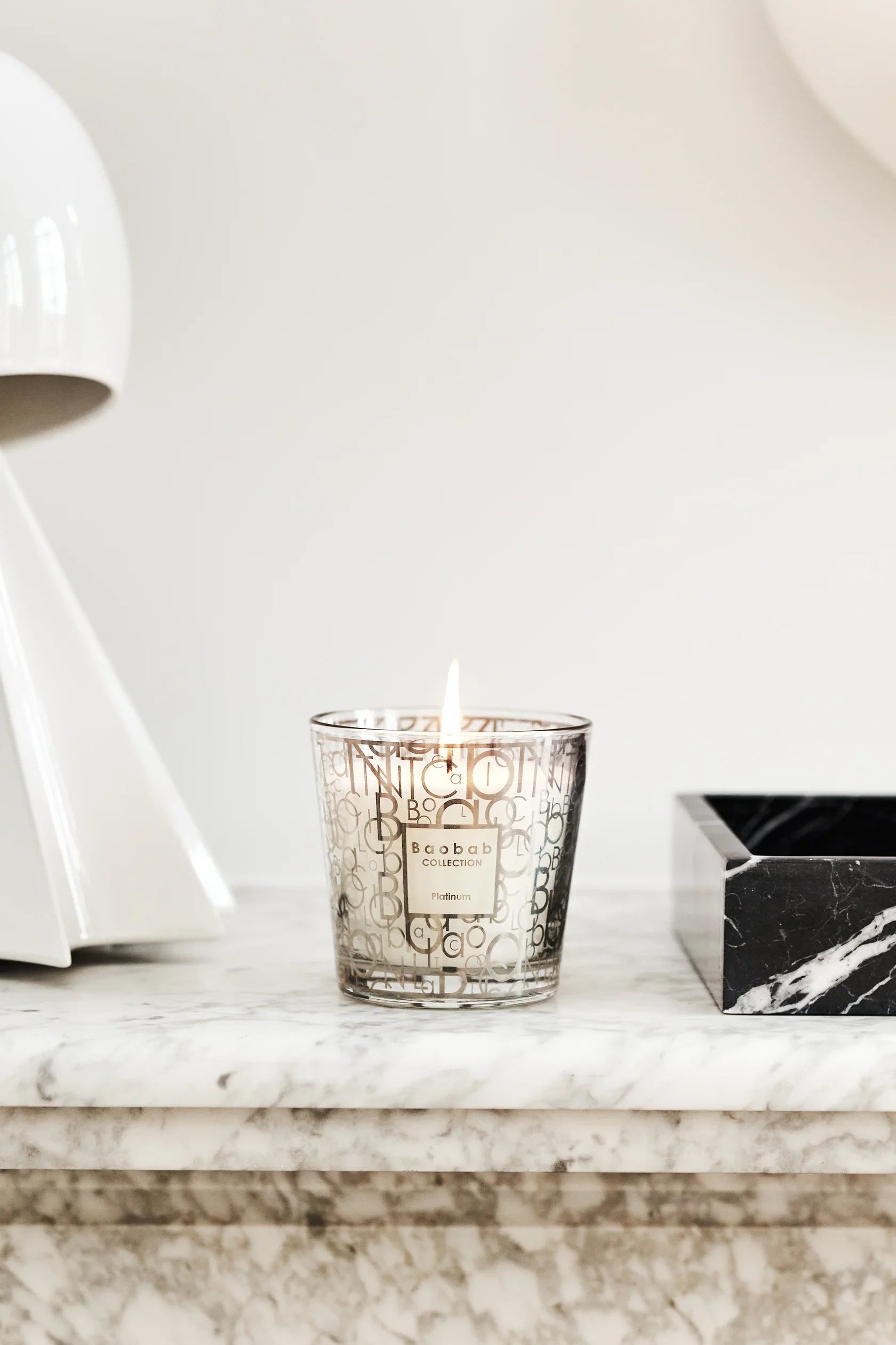 Baobab Collection scented candle My First Baobab in elegant glass, burning with fresh grapefruit and amber fragrance.