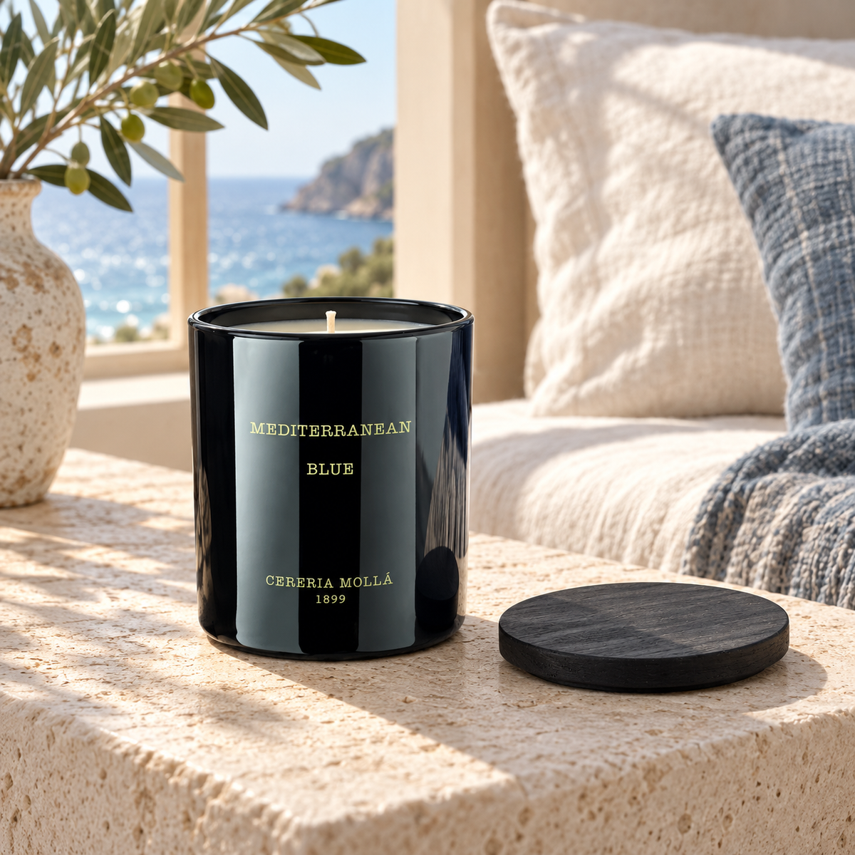 Cereria Molla Mediterranean Blue Black 230 g candle in a sunlit coastal bedroom