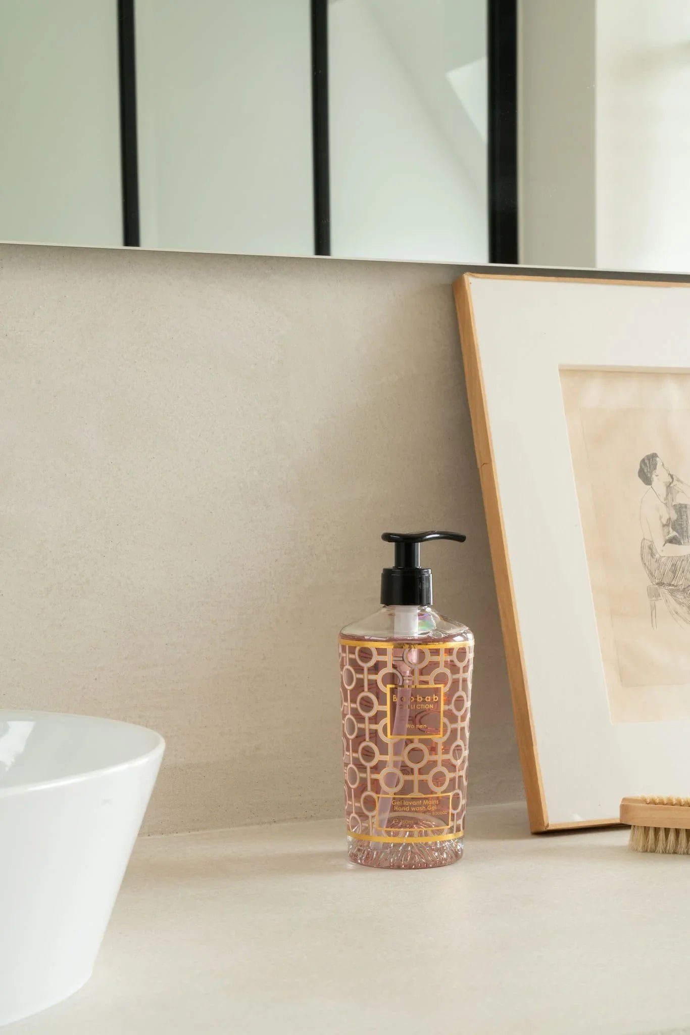 Baobab Collection women hand wash gel in decorative pink bottle on bathroom counter.