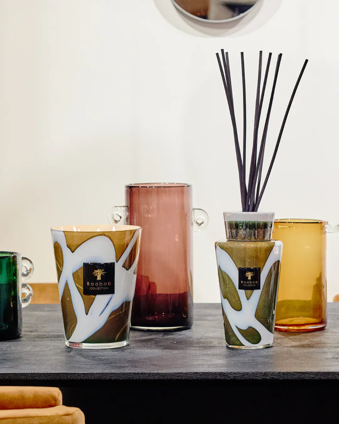 Baobab Collection decorative diffusers and candles displayed on a table, showcasing various elegant glass designs.