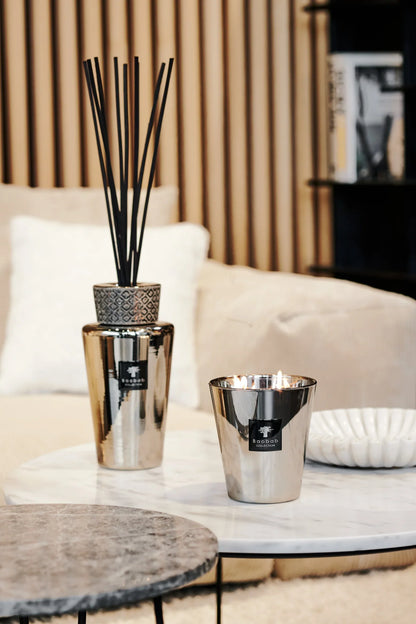 Baobab Collection TOTEM Platinum diffuser and candle on a marble table in a cozy interior setting.