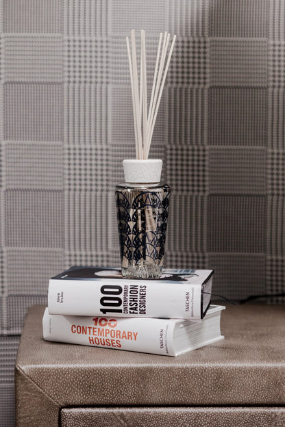 Baobab Collection Manhattan diffuser on stacked books, featuring art deco design and fragrance reeds.