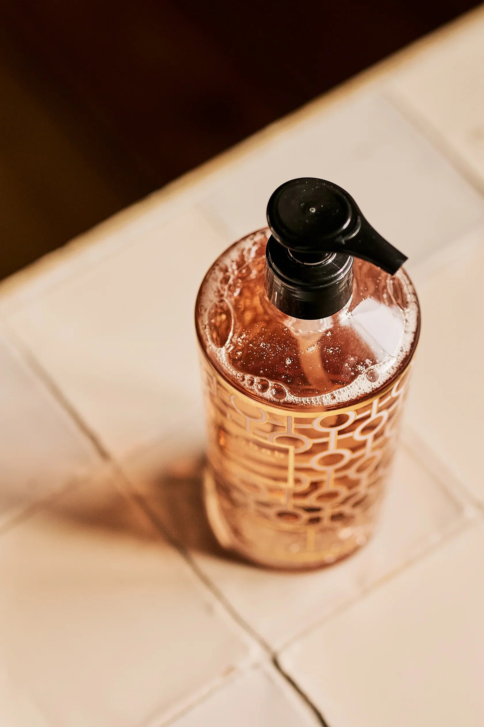 Baobab Collection hand wash gel bottle with gold and pink design on countertop, showcasing foamy moisturizing formula.
