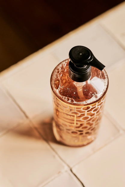 Baobab Collection hand wash gel bottle with gold and pink design on countertop, showcasing foamy moisturizing formula.