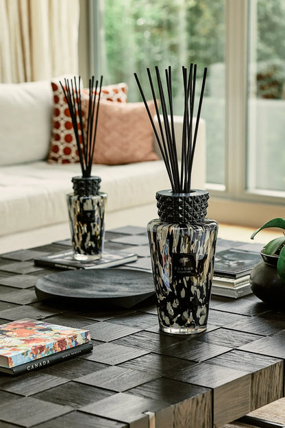 Decorative Baobab Collection TOTEM PEARLS BLACK diffusers on a modern coffee table, showcasing elegant glass design.