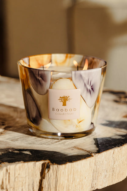 Baobab Collection Eilenroc scented candle in mauve and saffron glass on a wooden surface.