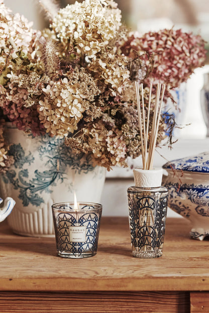 Baobab Collection gift box with Manhattan scented candle and diffuser beside floral arrangement.