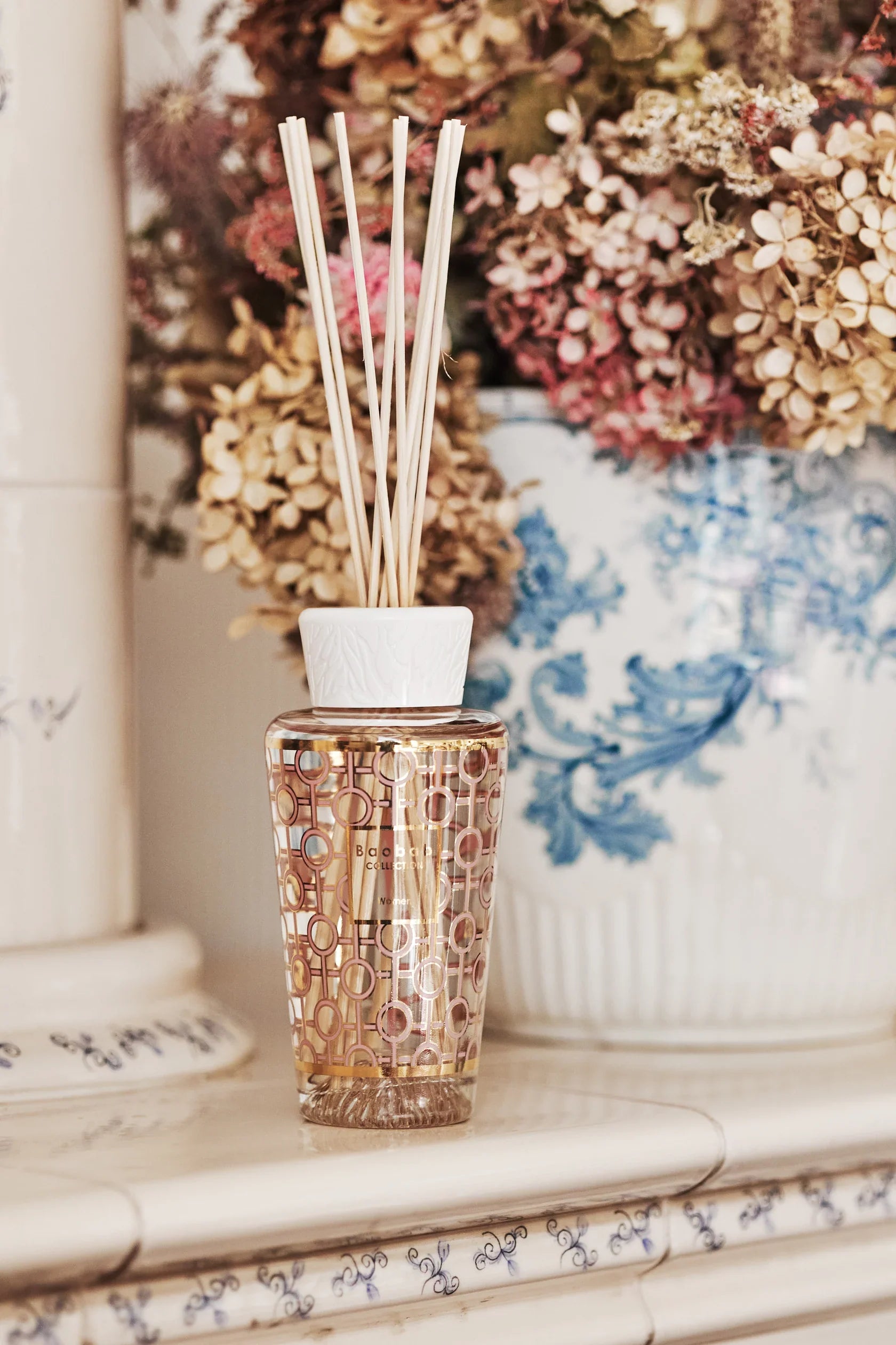 Decorative Baobab diffuser with feminine aroma, featuring gold and powder pink design and floral decor.