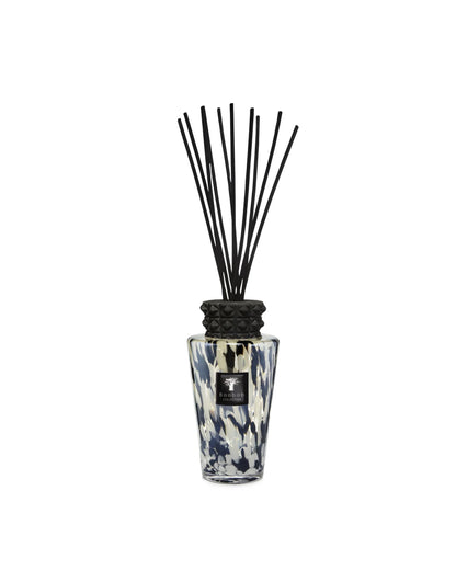 Hand-blown glass diffuser with black and iridescent design, featuring striking ceramic cap and black reeds.