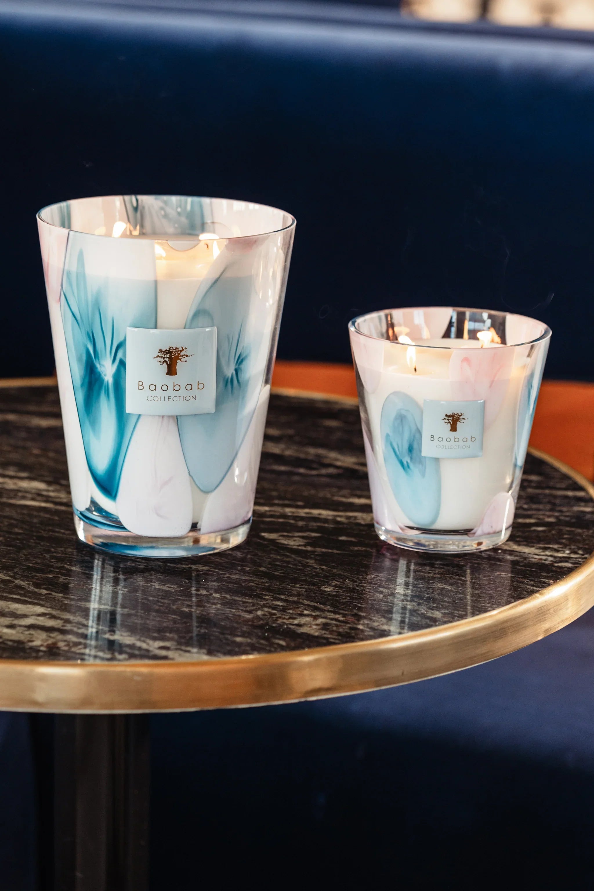 Baobab Collection Riviera Leopolda scented candles in pink and blue glass on a table.