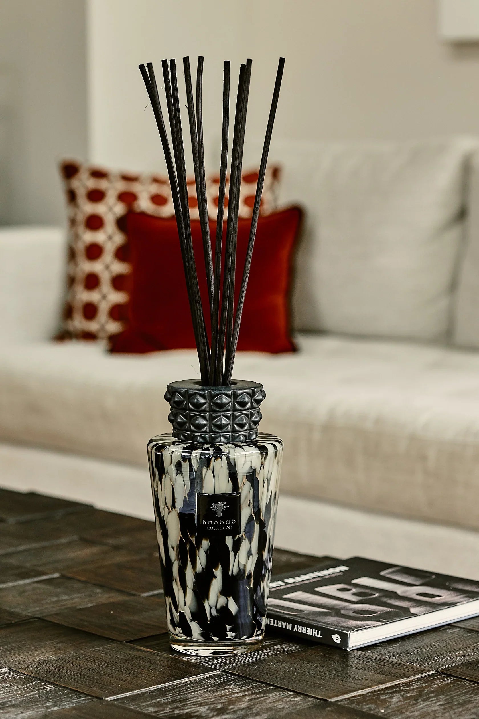 Baobab Collection TOTEM PEARLS BLACK reed diffuser with black sticks in a decorative glass vase on a wooden table