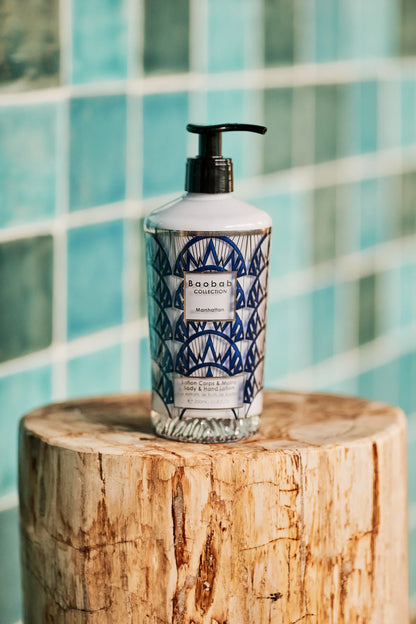 Baobab Collection Manhattan body and hand lotion in ornate glass bottle on wooden stump.
